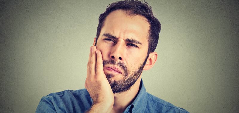 man experiencing tooth pain after his dental crown fell out