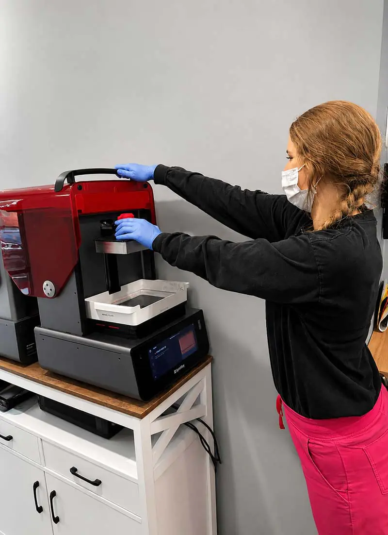 Dental staff member operating a resin 3D printer
